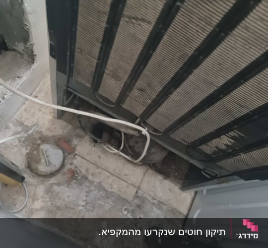 חלק אחורי של מקרר עם צינורות וחוטים